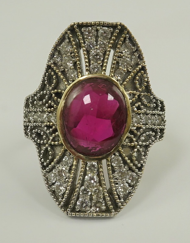 A gold, cabochon ruby and diamond cluster set upfinger ring